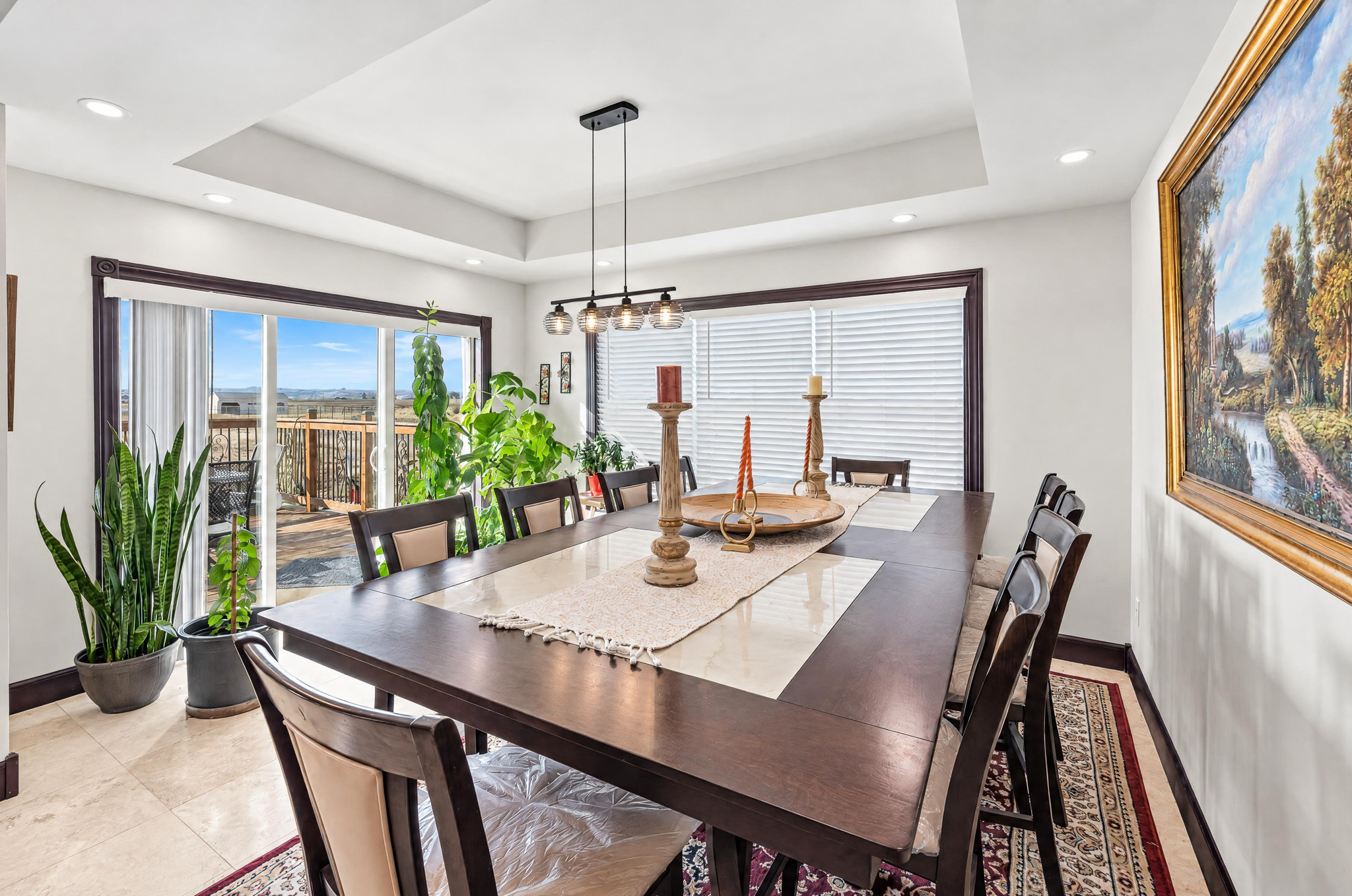 Open dining and living area with glass doors connecting to the outdoor deck and Colorado acreage.